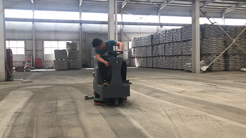 駕駛式洗地機(jī)在倉庫水泥地面上使用
